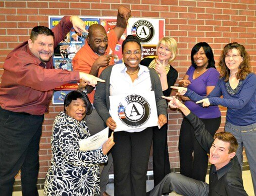 AmeriCorps volunteer Erin Crouch (center, holding the sign) with the Winning Futures team.